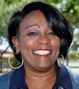 Patricia Whorton, REALTOR® at Keller Williams Arizona Realty, smiling, facing forward, wearing a denim jacket and large gold hoop earrings for Black History Month 2022