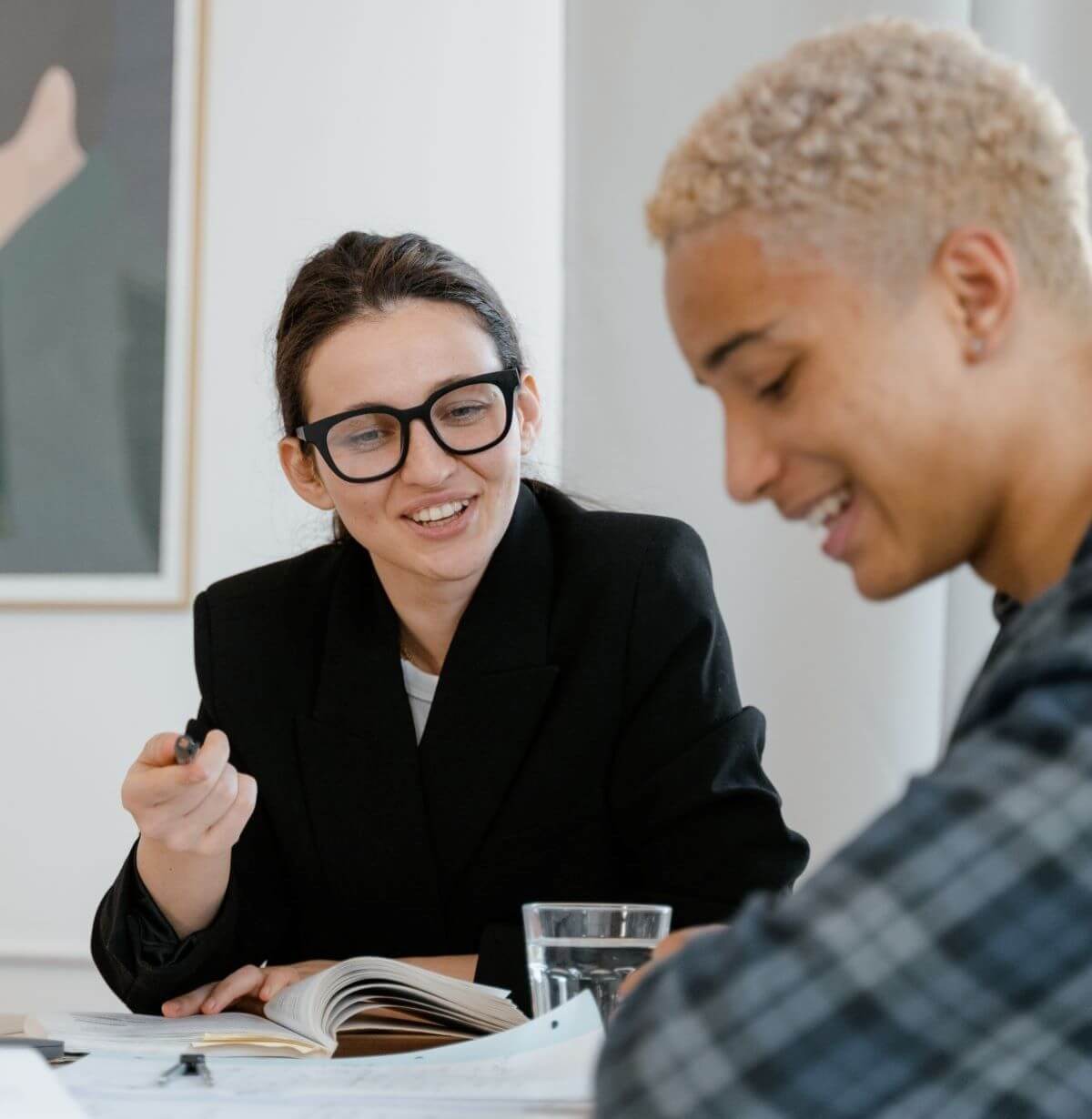 Woman with dark hair and glasses, smiling, talking to man with light hair and blue check shirt, about what exactly does the market center provide for real estate agents.