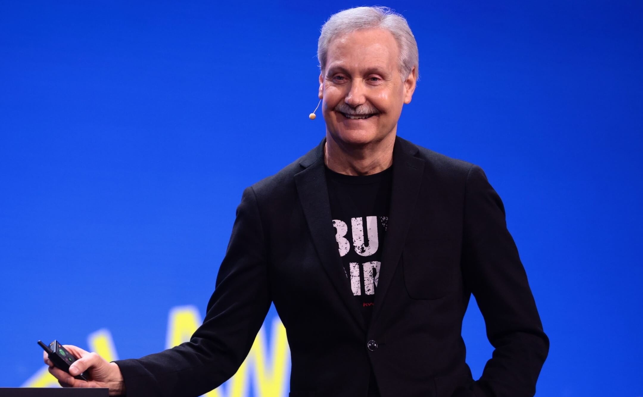 2002 Family Reunion Recap image featuring Gary Keller wearing a black jacket, black t-shirt, with short white hair, smiling, in front of a blue background.