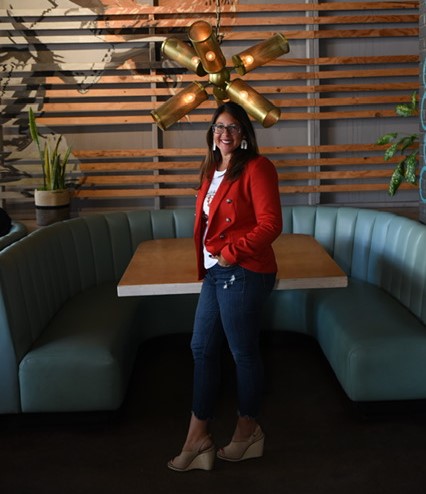 Meet Samantha Malcolm! An interview with Samantha Malcolm, REALTOR® and Owner of Sold by Samantha at Keller Williams Arizona Realty. Samantha has long dark hair, is smiling, and is wearing a red jacket and white t-shirt.