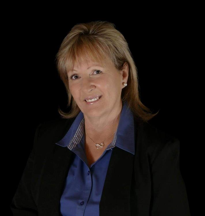 Meet Kellie Rutherford. An interview with Kellie Rutherford, REALTOR® at Sold by Kellie Rutherford, Keller Williams Northern Arizona. Kellie also manages Prescott Has It! with information about the KRC network and all things Prescott. Kellie is smiling, has blonde hair, is wearing a blue shirt and dark jacket.